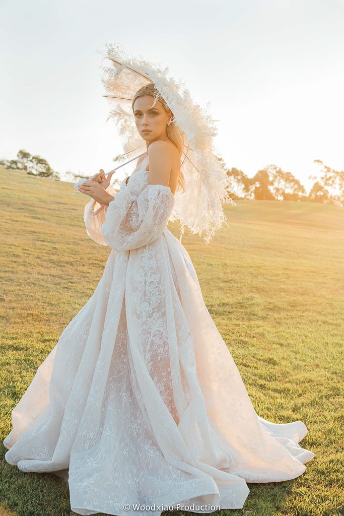 Romantic Bridal Dress with Everlasting Flower Umbrella in the sunset. Beautiful wedding gown and the floral umbrella showcase the beauty of the bride in the bridal photoshoot. 